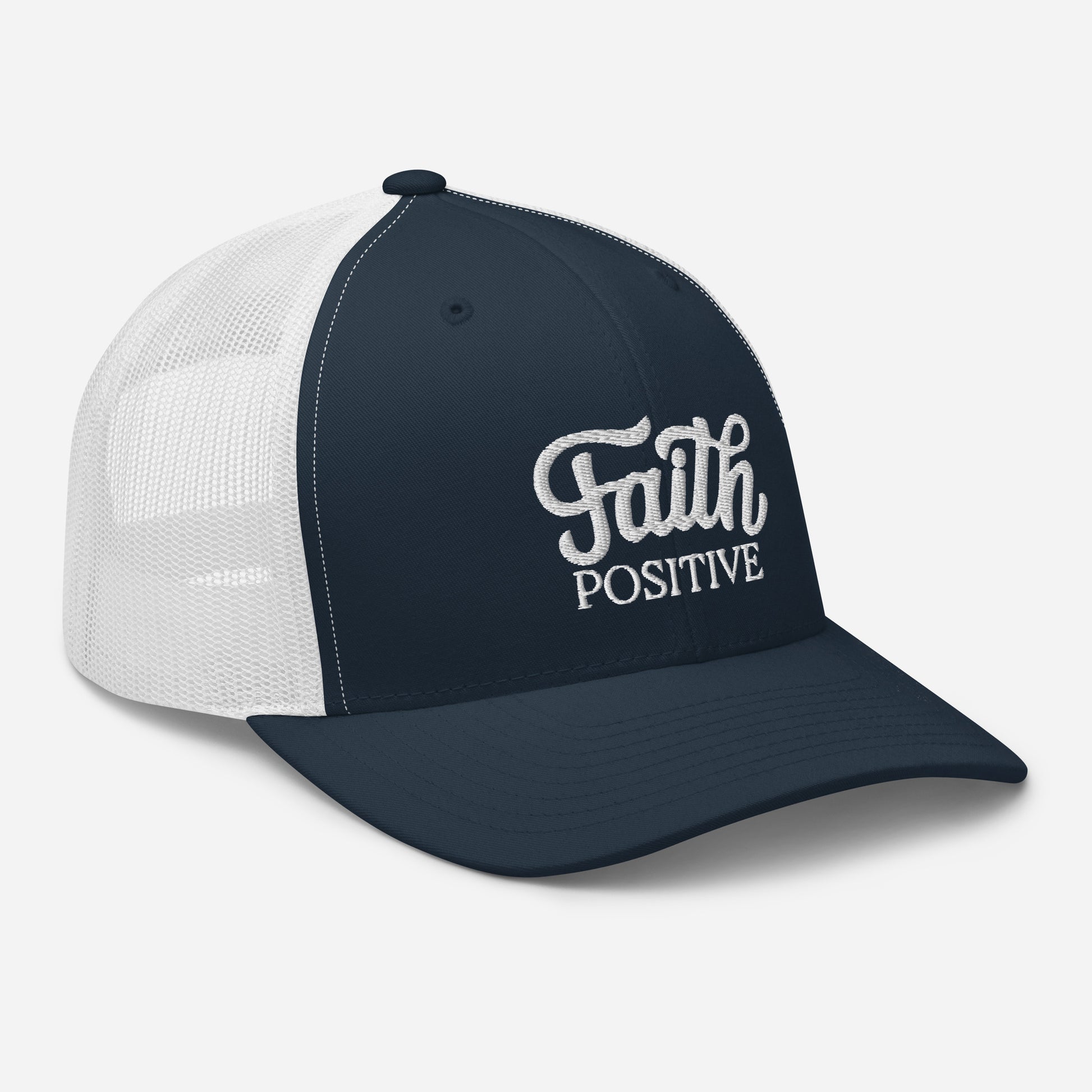 This is the Faith Positive Original trucker hat. The Faith Positive logo is embroidered on the front with white thread. This hat has a white mesh back with a navy blue front and bill. This is a side view of the product.