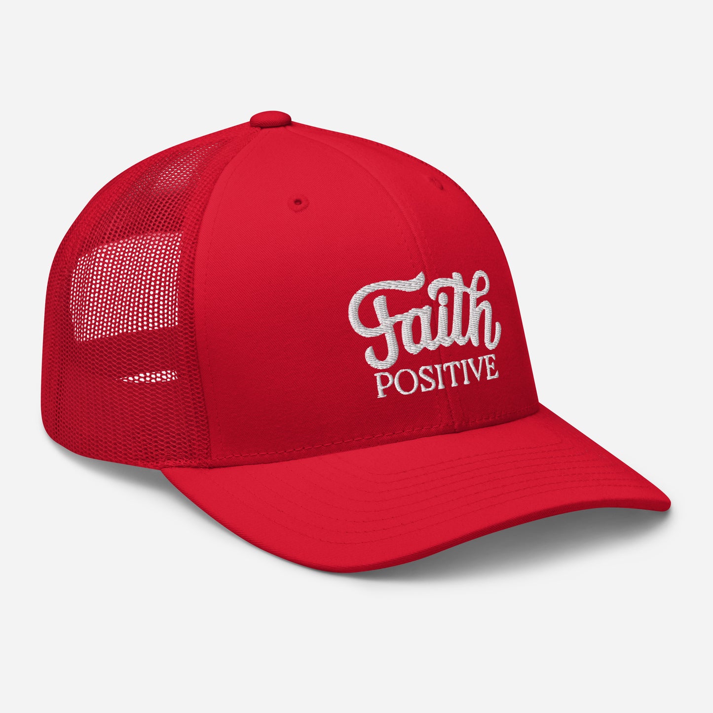 This is the Faith Positive Original trucker hat. The Faith Positive logo is embroidered on the front with white thread. This hat has a red mesh back with a red front and bill. This is the side view of the product.